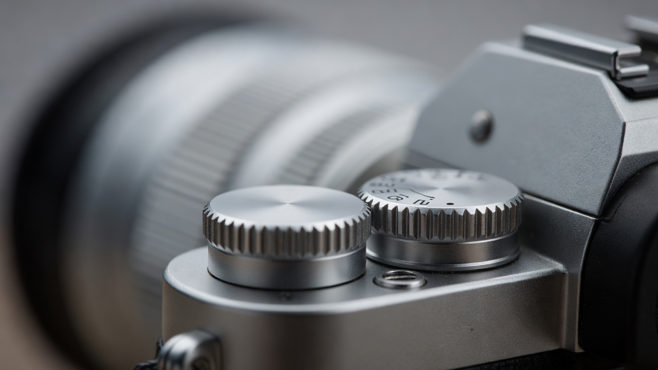 Macro close-up of a camera's aperture ring and shutter speed dial in soft focus